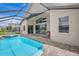 Stunning view of the pool area, sliding glass doors, covered lanai, and lush backyard at 10734 Banfield Dr, Riverview, FL 33579