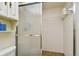 Functional bathroom with a glass shower, storage cabinet, and tiled walls at 11000 Gulf Blvd # 703, Treasure Island, FL 33706