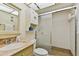 Well-lit bathroom featuring a vanity with marble countertop, glass shower, and built-in storage at 11000 Gulf Blvd # 703, Treasure Island, FL 33706
