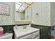 Charming bathroom featuring floral wallpaper, a vanity with storage, and tiled accents at 11000 Gulf Blvd # 703, Treasure Island, FL 33706