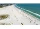 An aerial view shows a scenic beach with crystal water and lots of yellow umbrellas at 11000 Gulf Blvd # 703, Treasure Island, FL 33706