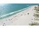 High-angle shot of the beach, capturing sunbathers and crystal-clear ocean waves, perfect for alt image tag at 11000 Gulf Blvd # 703, Treasure Island, FL 33706