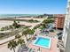 Relaxing pool area featuring blue waters, lounge chairs, palm trees, and clear ocean views at 11000 Gulf Blvd # 703, Treasure Island, FL 33706