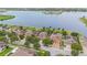 Aerial view of homes backing to a lake with green lawns and mature trees at 11603 Heron Watch Pl, Riverview, FL 33569