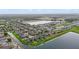 Aerial view showcases a well-planned community with serene lakes and beautifully landscaped homes under a partly cloudy sky at 11603 Heron Watch Pl, Riverview, FL 33569