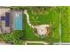 Aerial view of the backyard featuring a screened-in pool, outdoor fire pit and landscaped yard at 11603 Heron Watch Pl, Riverview, FL 33569