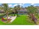 Beautiful backyard featuring a sparkling pool, lush landscaping, and a cozy fire pit area at 11603 Heron Watch Pl, Riverview, FL 33569