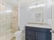 Bathroom with tiled walk-in shower, blue vanity with marble countertop, and soft blue walls at 11603 Heron Watch Pl, Riverview, FL 33569