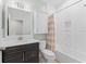 Bright bathroom featuring shower-tub combo with decorative tile, and dark wood vanity at 11603 Heron Watch Pl, Riverview, FL 33569