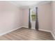 Cozy bedroom with wood-look floors, a neutral wall color, and a window with curtains at 11603 Heron Watch Pl, Riverview, FL 33569