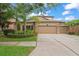 Charming home featuring a three-car garage and beautifully landscaped front yard with mature palm trees at 11603 Heron Watch Pl, Riverview, FL 33569