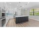 Modern kitchen features white cabinetry, stainless steel appliances, and a center island with quartz countertop at 11603 Heron Watch Pl, Riverview, FL 33569