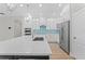 Kitchen featuring white cabinets, quartz countertops, a stainless refrigerator and modern appliances at 11603 Heron Watch Pl, Riverview, FL 33569