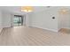 Bright living room with wood floor, sliding door access to pool, and modern chandelier at 11603 Heron Watch Pl, Riverview, FL 33569