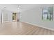 Bright living room with wood-look floors, ceiling fan, and sliding glass doors to the lanai at 11603 Heron Watch Pl, Riverview, FL 33569