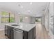 Open-concept living room with wood floors, modern lighting, and sliding glass doors leading to a pool at 11603 Heron Watch Pl, Riverview, FL 33569