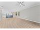 Spacious open floor plan with kitchen, island, wood floor, ceiling fan and neutral wall colors at 11603 Heron Watch Pl, Riverview, FL 33569