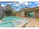 Relaxing pool area with crystal-clear water, spa, sun loungers, and screened enclosure at 11603 Heron Watch Pl, Riverview, FL 33569