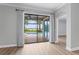 Living area view through sliding glass doors to screened in lanai, pool and lake at 11603 Heron Watch Pl, Riverview, FL 33569