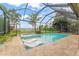 Screened-in pool area featuring two in-pool lounge chairs and lush landscaping at 11603 Heron Watch Pl, Riverview, FL 33569