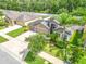 An aerial view showing the home's stone facade, three-car garage, backyard, and landscaping at 12729 Flatwood Creek Dr, Gibsonton, FL 33534