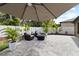 An outdoor patio with outdoor seating, a large shade umbrella, landscaping, and privacy fencing at 12729 Flatwood Creek Dr, Gibsonton, FL 33534