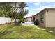 Landscaped backyard with grassy lawn, stone patio, outdoor seating, and privacy fence, perfect for relaxing at 12729 Flatwood Creek Dr, Gibsonton, FL 33534