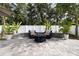 Beautiful backyard patio features a fire pit, elegant seating, lush landscaping, and a privacy fence at 12729 Flatwood Creek Dr, Gibsonton, FL 33534