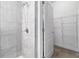 Bathroom featuring a glass shower, gray tile and a view into the walk-in closet at 12729 Flatwood Creek Dr, Gibsonton, FL 33534