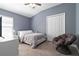 Comfortable bedroom features neutral walls, ceiling fan, a cozy chair, and ample natural light at 12729 Flatwood Creek Dr, Gibsonton, FL 33534