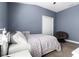 Comfortable bedroom with neutral walls, a cozy gray chair, and great natural light at 12729 Flatwood Creek Dr, Gibsonton, FL 33534