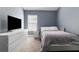 Bedroom featuring a dresser with a TV, a window and a bed with a gray blanket at 12729 Flatwood Creek Dr, Gibsonton, FL 33534