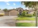 Charming single-Gathering home featuring a stone facade, three-car garage, and lush landscaping at 12729 Flatwood Creek Dr, Gibsonton, FL 33534
