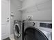 The laundry room features modern stainless steel appliances and convenient overhead shelving at 12729 Flatwood Creek Dr, Gibsonton, FL 33534