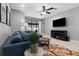 Comfortable living room featuring a blue sectional sofa, television, and access to the outdoor patio at 12729 Flatwood Creek Dr, Gibsonton, FL 33534