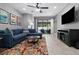 Inviting living room with a comfortable blue sectional sofa and sliding glass doors to the patio at 12729 Flatwood Creek Dr, Gibsonton, FL 33534