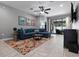 Bright living room with a blue sectional sofa, patterned rug, and view of the outdoor patio at 12729 Flatwood Creek Dr, Gibsonton, FL 33534