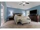 Serene main bedroom features blue walls, vaulted ceiling, large bed, tv, and a cozy bench at 12729 Flatwood Creek Dr, Gibsonton, FL 33534