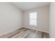 A well-lit bedroom with neutral walls, wood-look floors, and a window with blinds at 13016 Boggy Creek Dr, Riverview, FL 33579