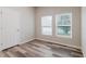 Bedroom featuring wood-look floors, neutral paint, and two bright windows at 13016 Boggy Creek Dr, Riverview, FL 33579