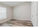 A cozy bedroom with neutral walls, wood-look floors, and a bright window with blinds at 13016 Boggy Creek Dr, Riverview, FL 33579