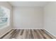 Bedroom with wood-look flooring, neutral walls, and a bright window at 13016 Boggy Creek Dr, Riverview, FL 33579