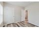 Cozy bedroom showing wood-look flooring and neutral walls, with two white doors in clear view at 13016 Boggy Creek Dr, Riverview, FL 33579