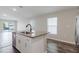 Bright kitchen with granite island featuring stainless steel appliances and wood flooring throughout at 13016 Boggy Creek Dr, Riverview, FL 33579