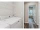 Bright laundry room featuring a white washer and dryer set and convenient wire shelving for storage at 13016 Boggy Creek Dr, Riverview, FL 33579