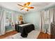 Calm bedroom includes wood floors, a ceiling fan, neutral walls, and abundant natural light at 1419 30Th N Ave, St Petersburg, FL 33704
