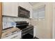 Well lit kitchen features white cabinets, stainless steel appliances, and decorative backsplash at 1419 30Th N Ave, St Petersburg, FL 33704