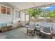 The screened patio has chairs, a small table, and a view of the backyard at 1419 30Th N Ave, St Petersburg, FL 33704