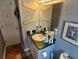 Hall bathroom featuring a single sink with green countertop, tile floors, and sign decorations at 16134 Ravendale Dr, Tampa, FL 33618