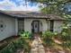 Charming home entrance featuring a decorative door, stone walkway, and mature landscaping at 16134 Ravendale Dr, Tampa, FL 33618